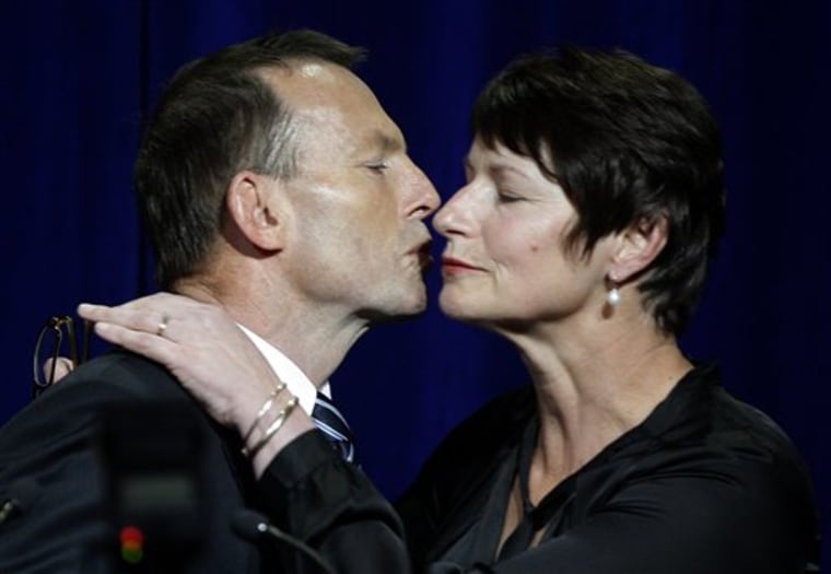 Liberal Party leader Tony Abbott, left, kisses his wife, Margie, as he address a crowd of supporters in Sydney, Sunday, Aug. 22, 2010, following a national election. Australians chose Saturday between giving their first female prime minister her own election mandate and returning to a conservative government after just three years. With more than 75 percent of the votes counted, the results were too close to call.  (AP Photo/Rick Rycroft)
